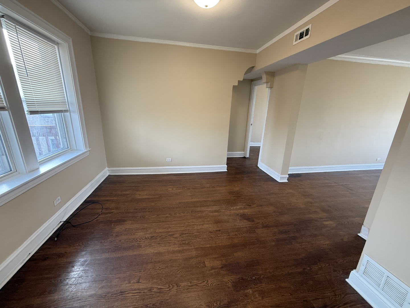 2805 North Kilbourn Avenue, Unit 3S Chicago, IL 60639 - Photo 6 of 13 a view of an empty room with wooden floor and a window