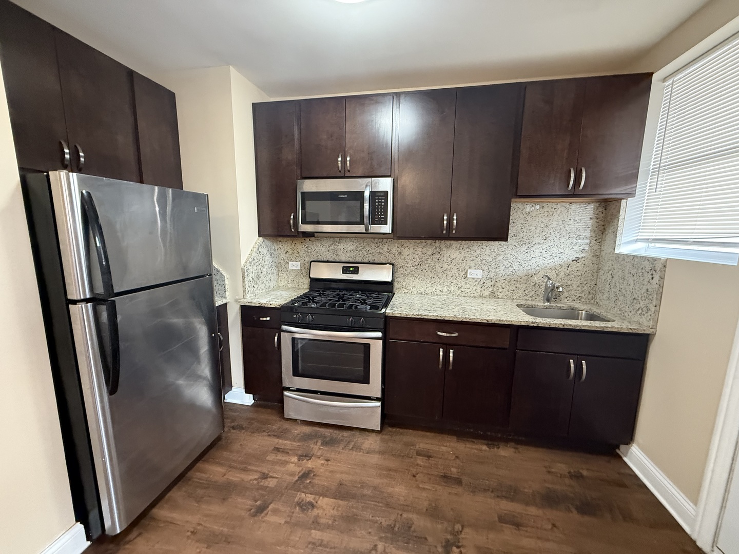 2805 North Kilbourn Avenue, Unit 3S Chicago, IL 60639 - Photo 7 of 13 a kitchen with granite countertop stainless steel appliances a refrigerator a stove a sink and a refrigerator