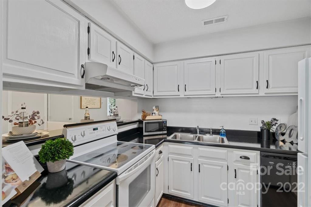 1606 Sharon Road West Charlotte, NC 28210 - Photo 6 of 19 a kitchen with granite countertop white cabinets and white appliances
