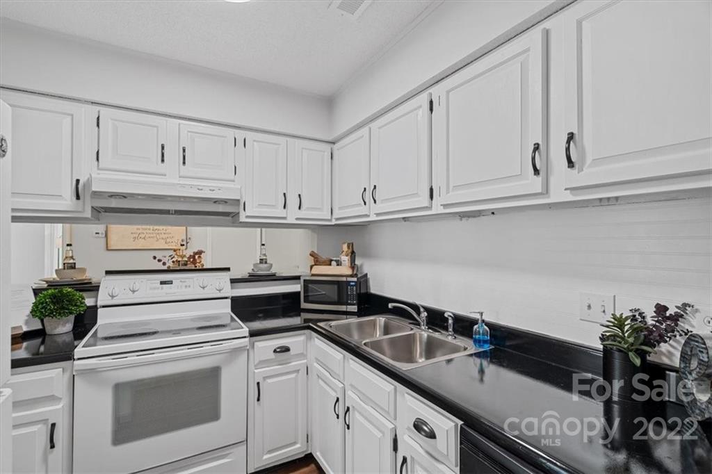 1606 Sharon Road West Charlotte, NC 28210 - Photo 7 of 19 a kitchen with granite countertop white cabinets and white appliances