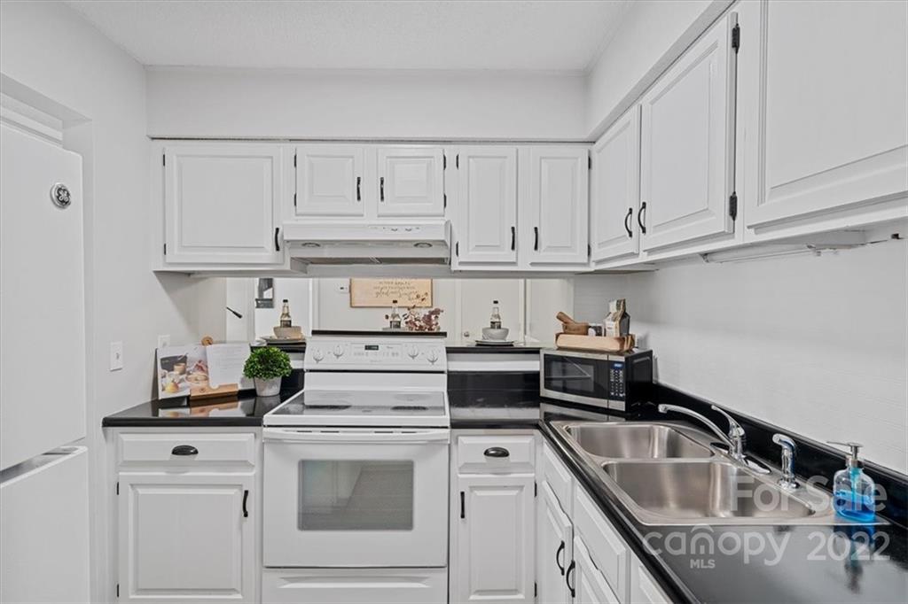 1606 Sharon Road West Charlotte, NC 28210 - Photo 8 of 19 a kitchen with white cabinets and white appliances
