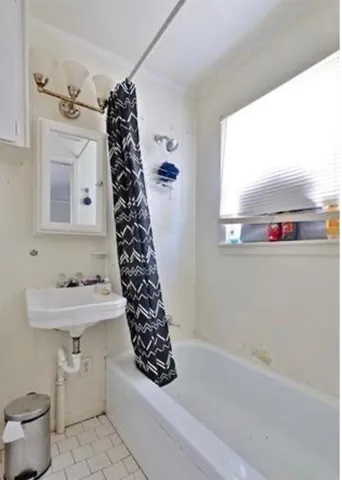 a bathroom with a sink a toilet and shower curtain