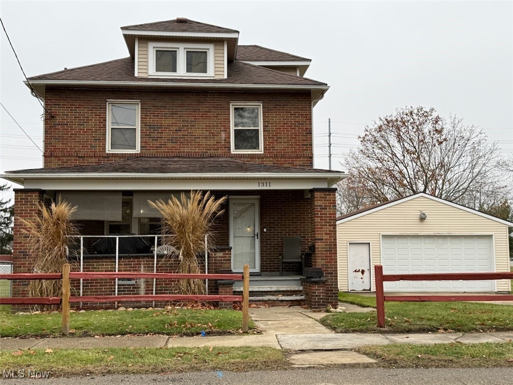 American foursquare style home with covered porch, an outdoor structure, a garage, and brick siding