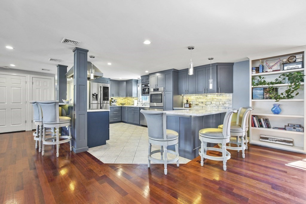 61 Court Road Braintree, MA 02184 - Photo 7 of 42 a kitchen with stainless steel appliances kitchen island granite countertop a refrigerator a stove a dining table and chairs with wooden floor