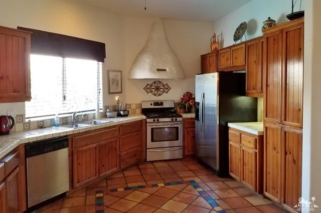 a kitchen with stainless steel appliances granite countertop a refrigerator and a sink