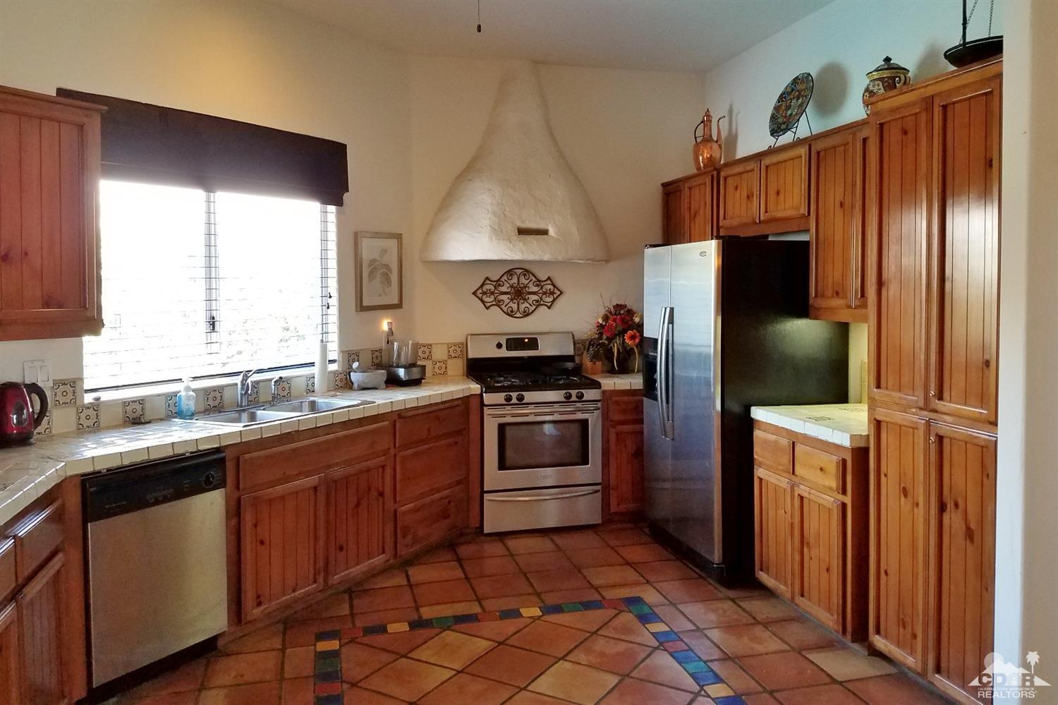 52225 Avenida Obregon La Quinta, CA 92253 - Photo 16 of 34 a kitchen with stainless steel appliances a stove a sink and a refrigerator