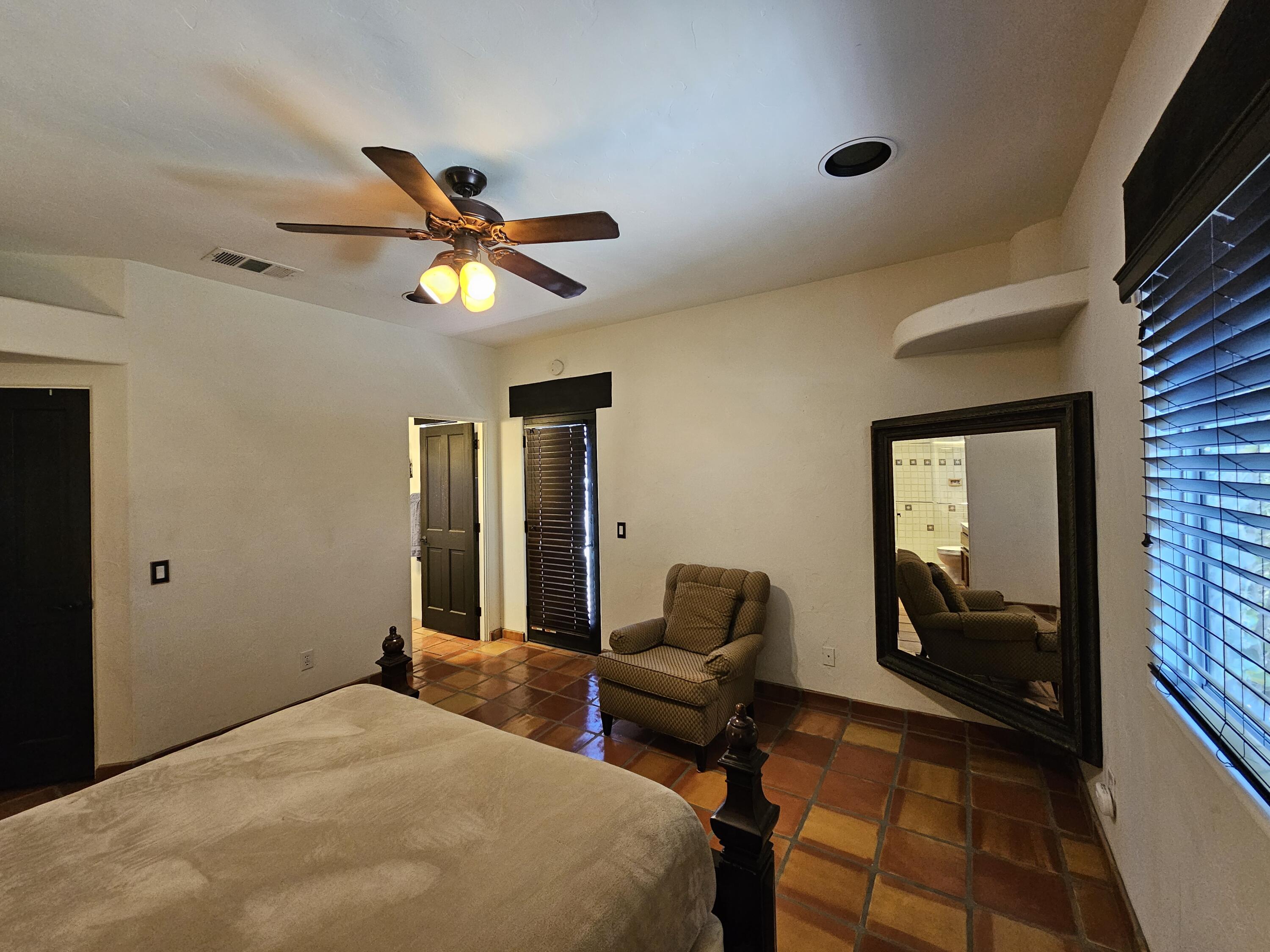 52225 Avenida Obregon La Quinta, CA 92253 - Photo 23 of 39 a bedroom with a bed and a chandelier