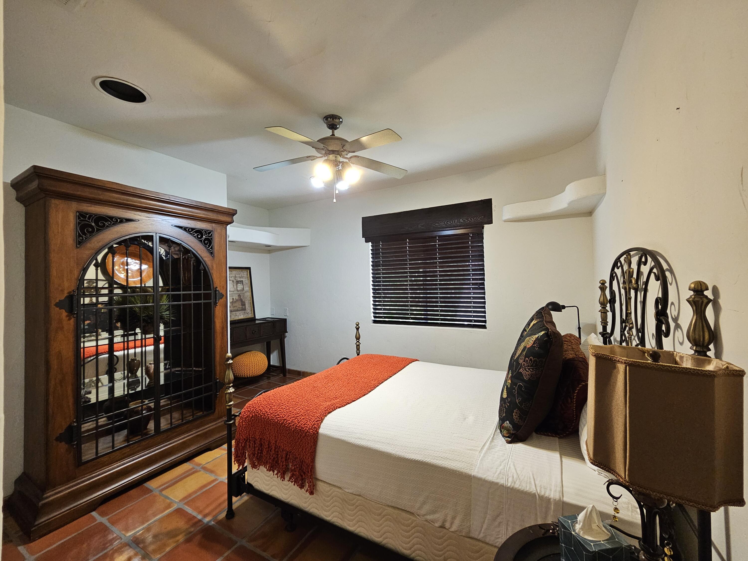 52225 Avenida Obregon La Quinta, CA 92253 - Photo 33 of 39 a bedroom with a bed a fireplace and a flat screen tv