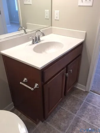 a bathroom with a sink vanity and a toilet
