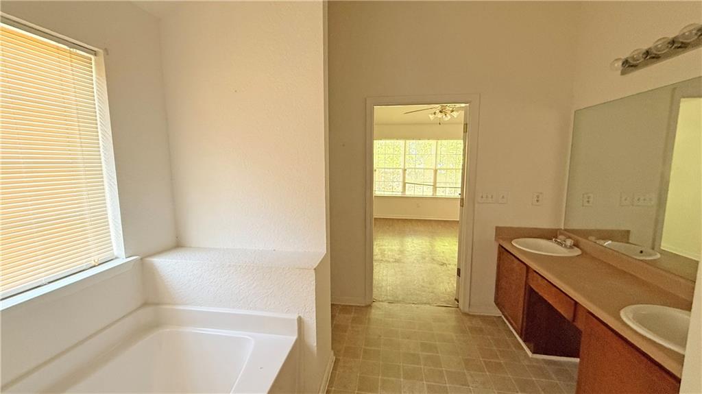 65 Lakeridge Court Covington, GA 30016 - Photo 14 of 17 a bathroom with a tub sink and mirror