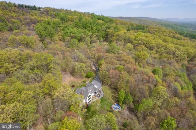an aerial view of a house with a yard basket ball court and outdoor seating