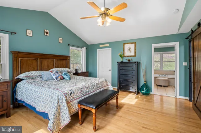 a dining room with wooden floor a chandelier a wooden table and chairs