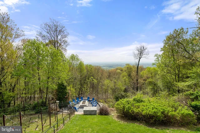 a aerial view of a house next to a big yard and large trees