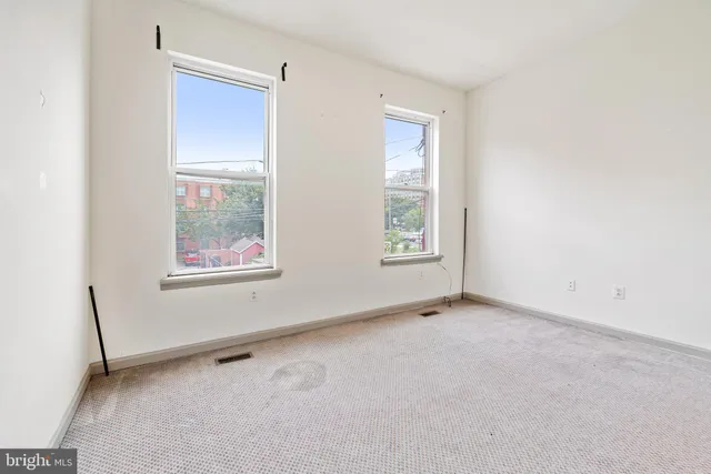 an empty room with windows and a ceiling fan