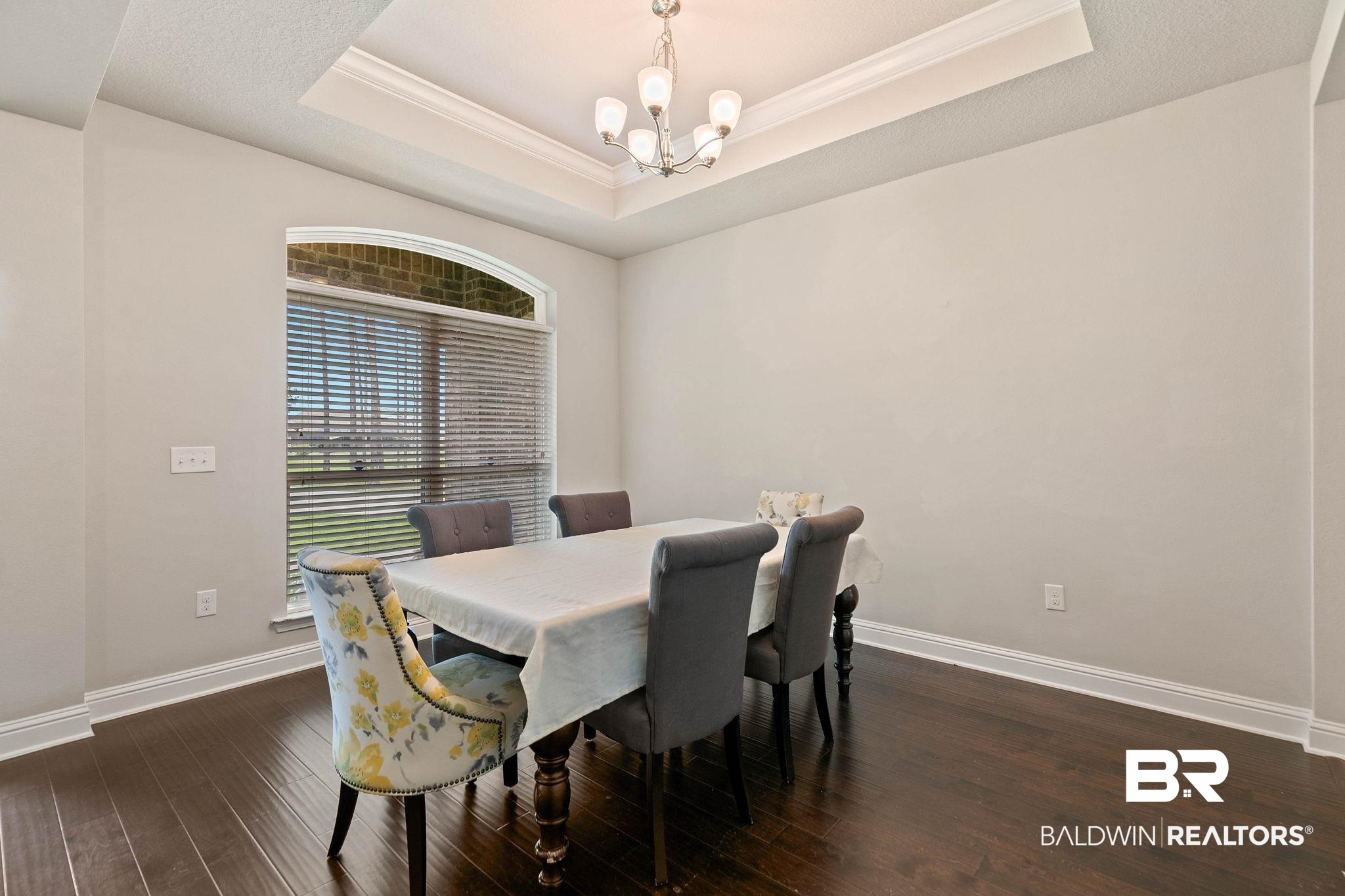 12750 B Jenkins Pit Road Daphne, AL 36527 - Photo 8 of 89 Dining space featuring a chandelier, dark wood-style floors, crown molding, and a tray ceiling