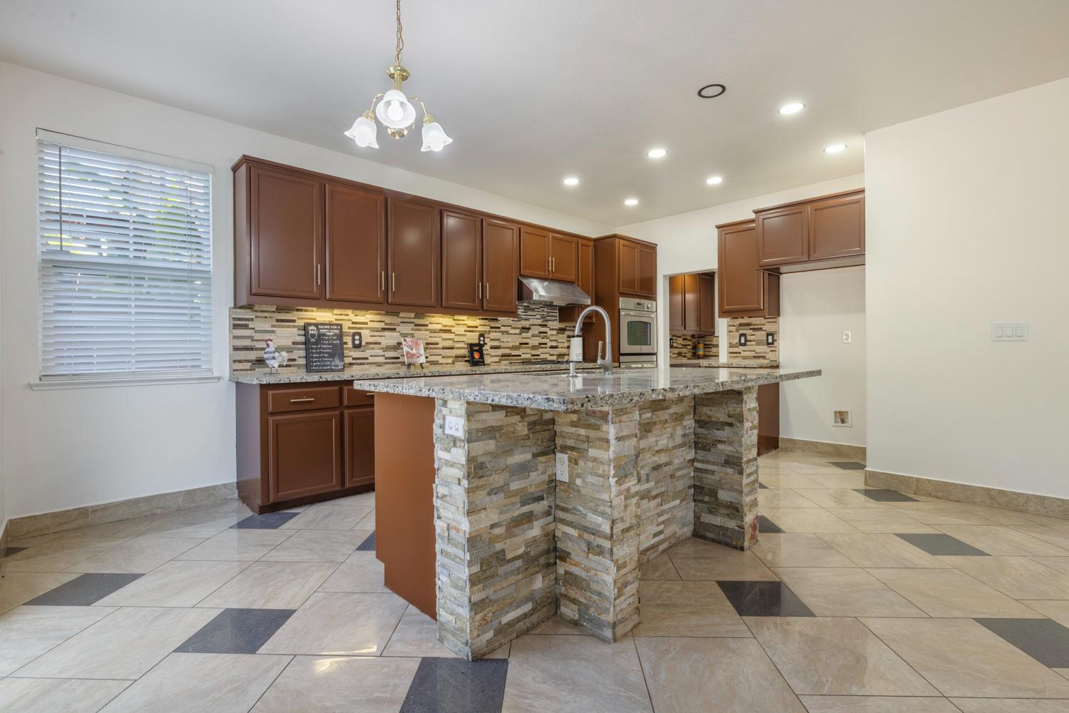 3105 Ripple Court Modesto, CA 95355 - Photo 13 of 46 a kitchen with kitchen island granite countertop a stove cabinets and refrigerator