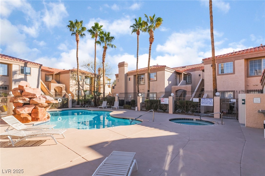 1851 Hillpointe Road, Unit 2912 Henderson, NV 89074 - Photo 27 of 28 Community pool featuring a residential view, a patio area, fence, and a hot tub