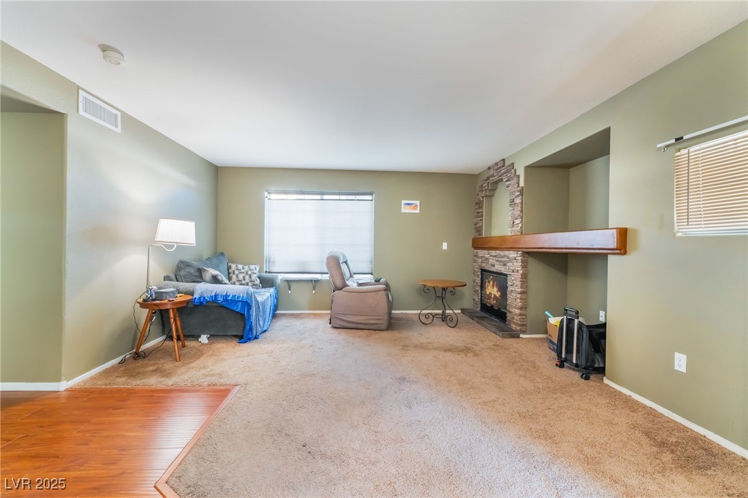 1851 Hillpointe Road, Unit 2912 Henderson, NV 89074 - Photo 9 of 28 Living area featuring carpet, visible vents, baseboards, and a stone fireplace