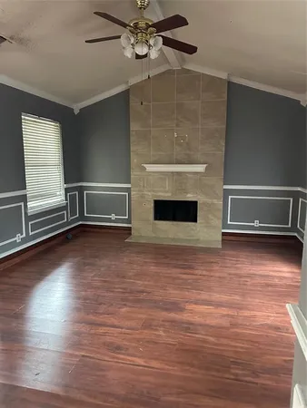 wooden floor fireplace and windows in an empty room