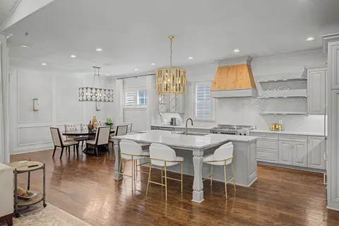 a kitchen with stainless steel appliances granite countertop a table and chairs in it