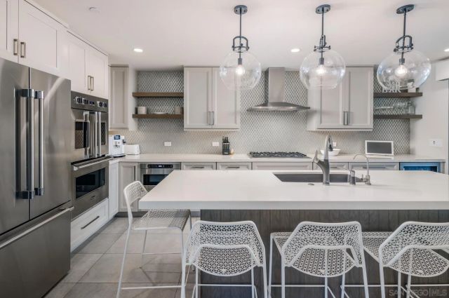 a kitchen with stainless steel appliances granite countertop a sink a stove a refrigerator and cabinets