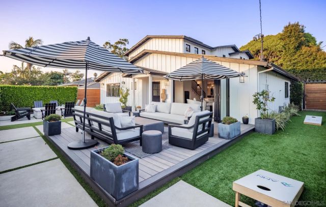 a view of a house with backyard and sitting area