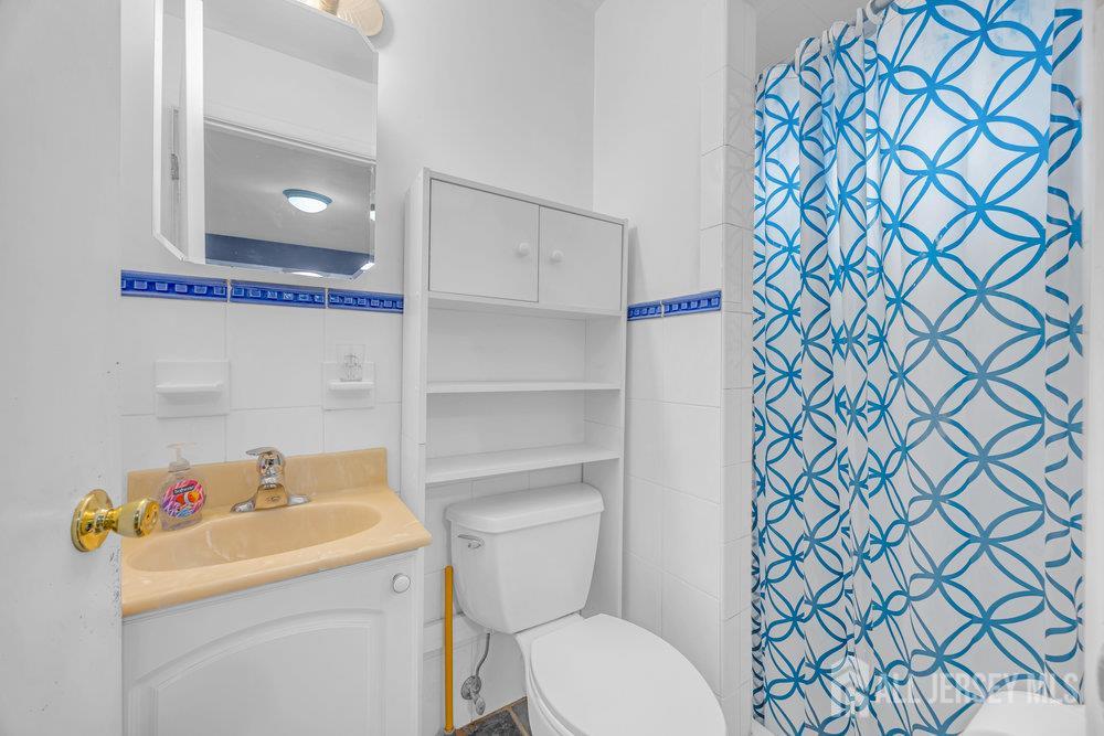 531 Chestnut Street Middlesex, NJ 08846 - Photo 22 of 42 a bathroom with a sink a toilet and a shower curtain