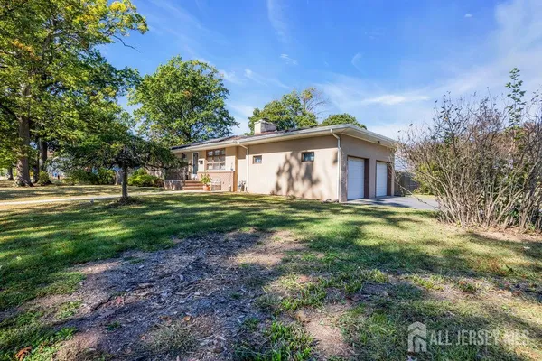 a view of a house with backyard and trees