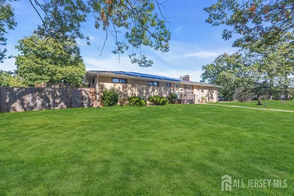 a view of a house with a yard and a tree