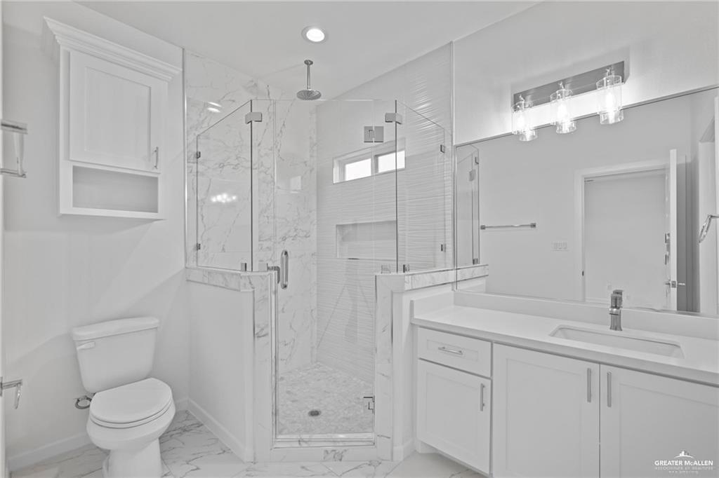 2737 East Conroe Road Edinburg, TX 78542 - Photo 11 of 14 a bathroom with a sink a toilet and a large mirror
