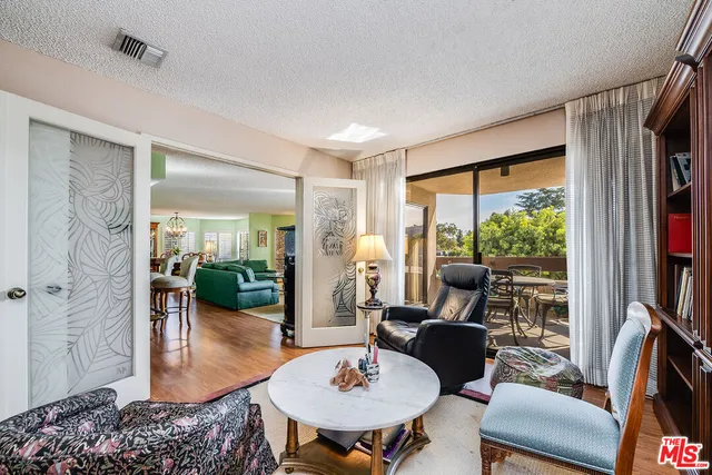 a living room with furniture fireplace and a large window