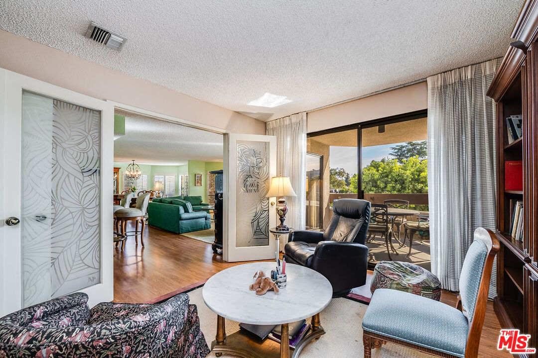 10409 Riverside Drive, Unit 203 Toluca Lake, CA 91602 - Photo 16 of 34 a living room with furniture fireplace and a large window