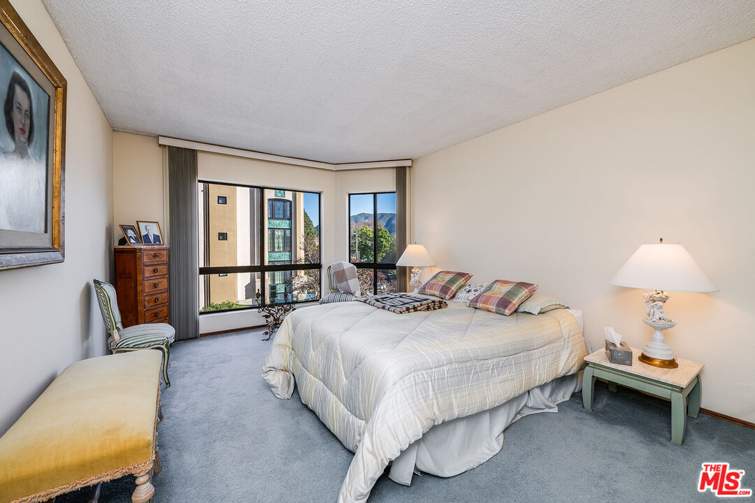 10409 Riverside Drive, Unit 203 Toluca Lake, CA 91602 - Photo 22 of 34 a bedroom with a bed and a couch