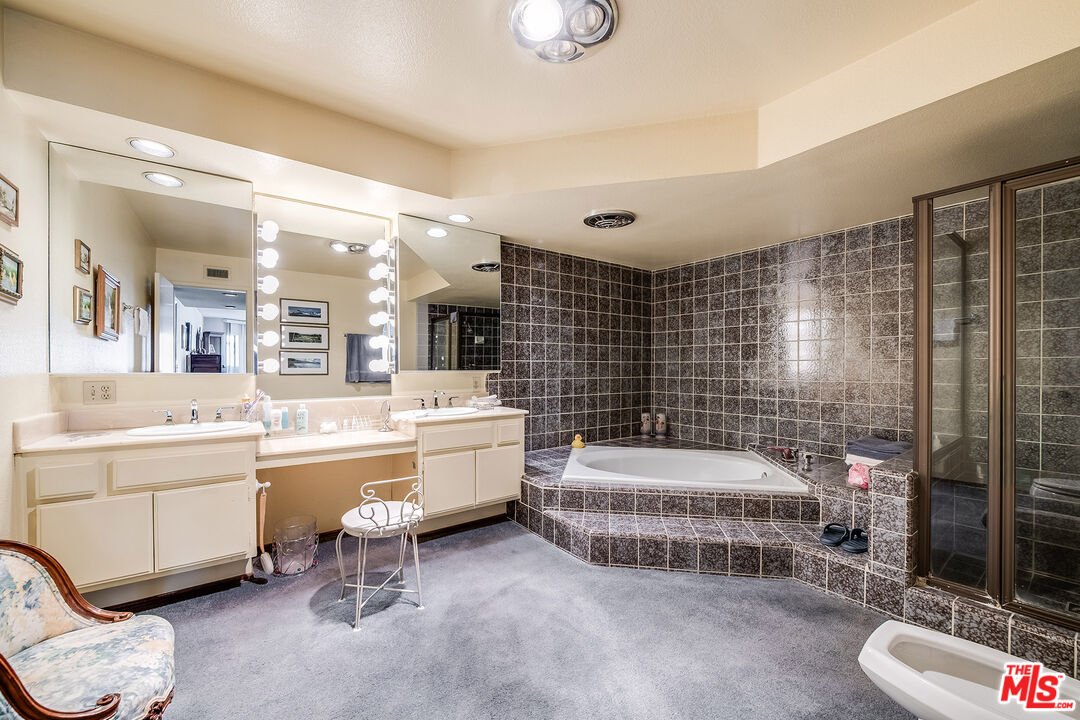 10409 Riverside Drive, Unit 203 Toluca Lake, CA 91602 - Photo 29 of 34 a room with a bed and a chandelier