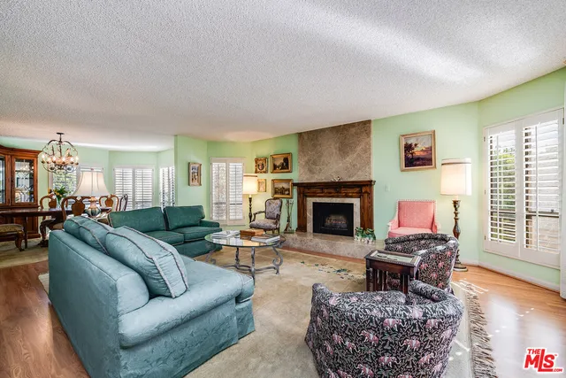 a living room with furniture a fireplace and wooden floor