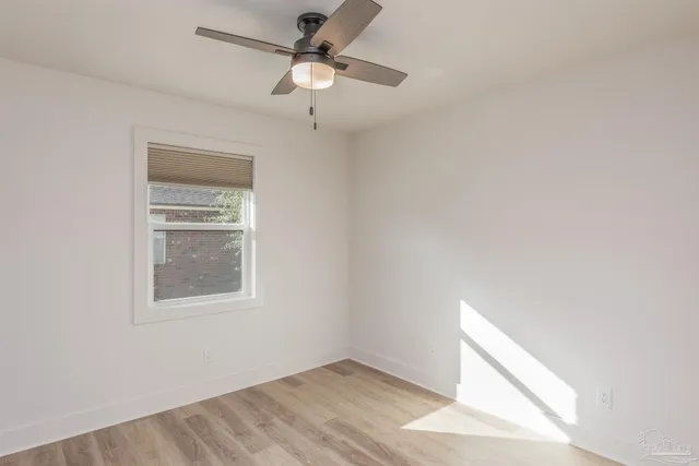 a view of an empty room with a chandelier fan