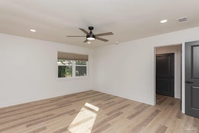 a view of a bedroom with a bed and a chandelier fan