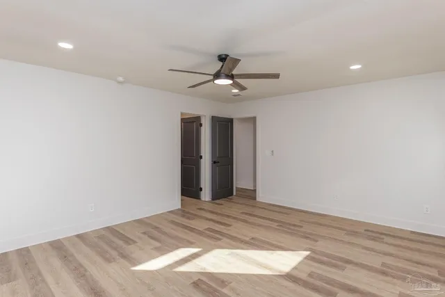 a view of a big room with wooden floor and a window