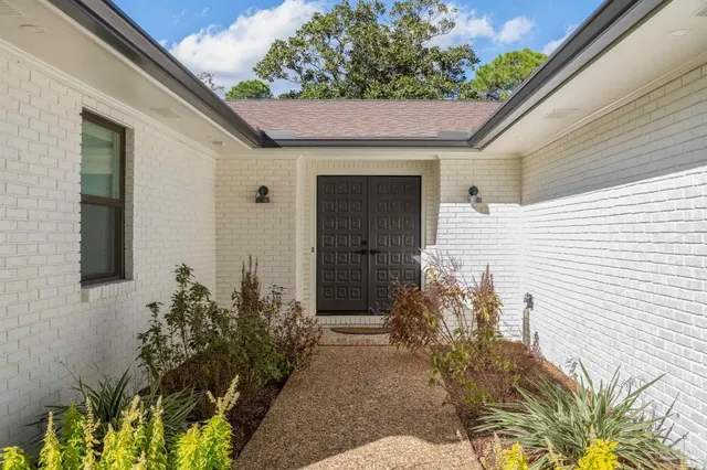 a front view of a house with a garden