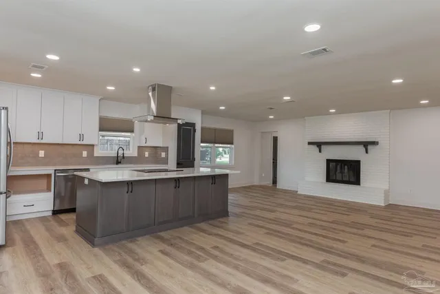a large kitchen with kitchen island a sink stainless steel appliances and cabinets