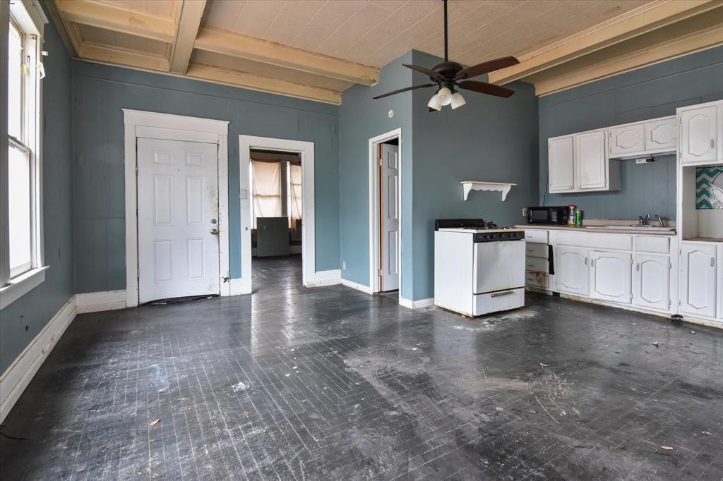 738 1st Street Southwest Paris, TX 75460 - Photo 15 of 25 Kitchen with white cabinetry, beamed ceiling, white gas range, ceiling fan, and black microwave