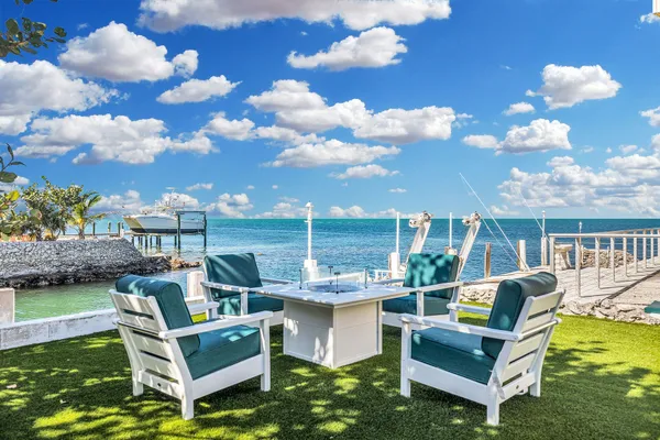 a view of a patio with couches chairs potted plants and lake view