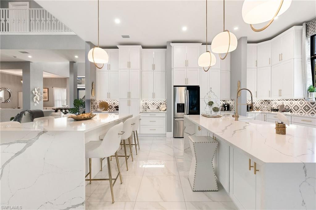 2227 21st Street Southwest Naples, FL 34117 - Photo 14 of 50 a large white kitchen with a large island oven a sink stainless steel appliances and cabinets