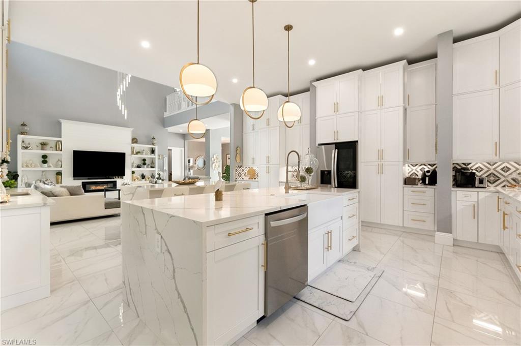 2227 21st Street Southwest Naples, FL 34117 - Photo 15 of 50 a large white kitchen with a large island oven a sink stainless steel appliances and cabinets