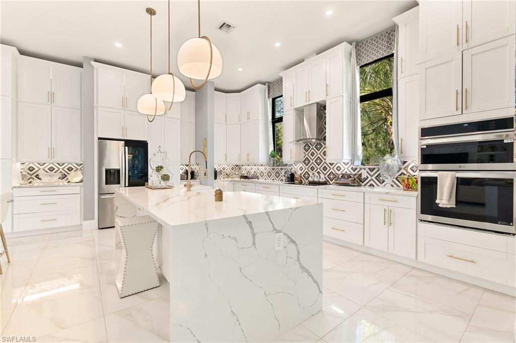 2227 21st Street Southwest Naples, FL 34117 - Photo 16 of 50 a large white kitchen with a sink and dishwasher with white cabinets