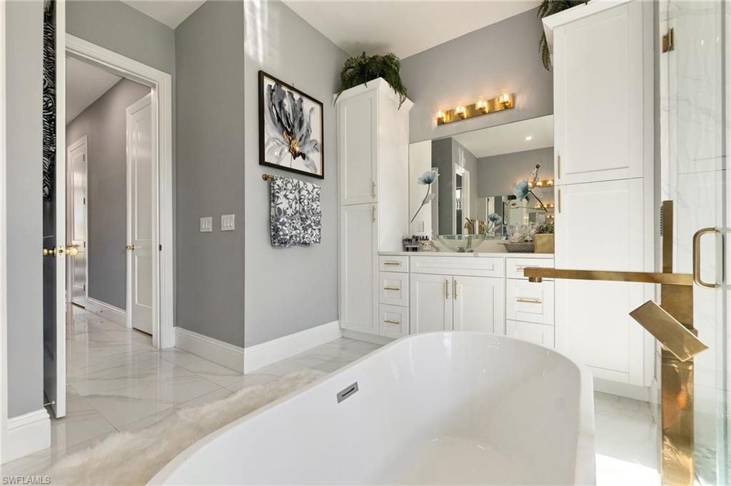 2227 21st Street Southwest Naples, FL 34117 - Photo 27 of 50 a spacious bathroom with a sink and a mirror