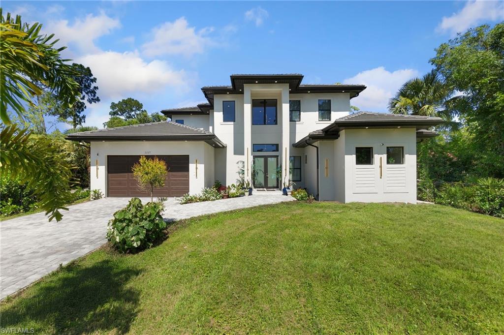 2227 21st Street Southwest Naples, FL 34117 - Photo 3 of 50 a front view of a house with a garden and plants