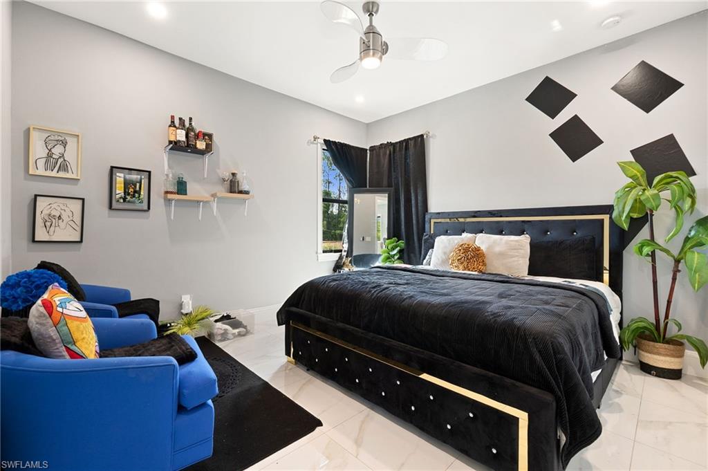 2227 21st Street Southwest Naples, FL 34117 - Photo 34 of 50 a bedroom with a bed and ceiling fan