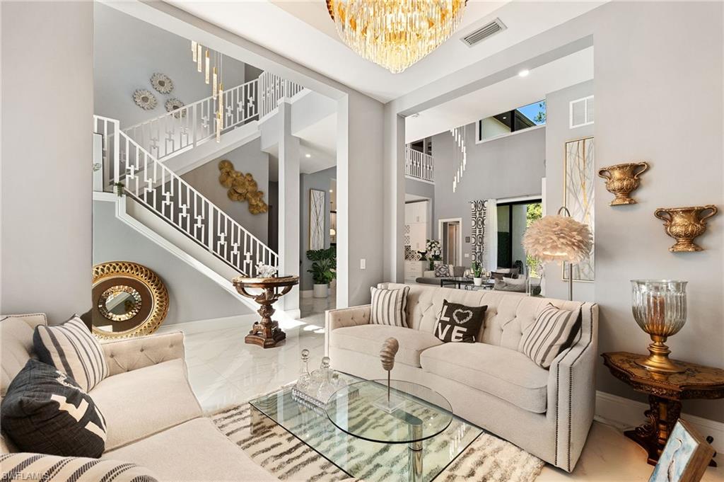 2227 21st Street Southwest Naples, FL 34117 - Photo 7 of 50 a living room with patio a fireplace and a floor to ceiling window