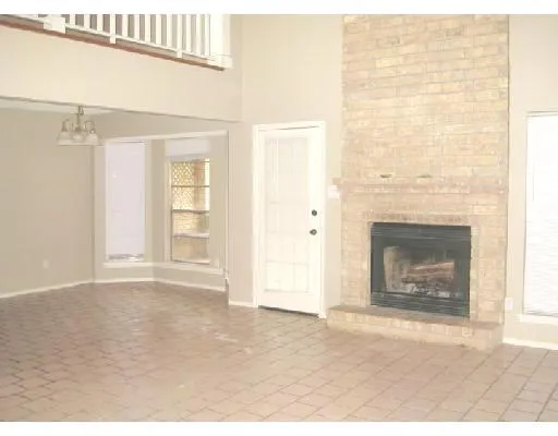 an empty room with windows and a fireplace